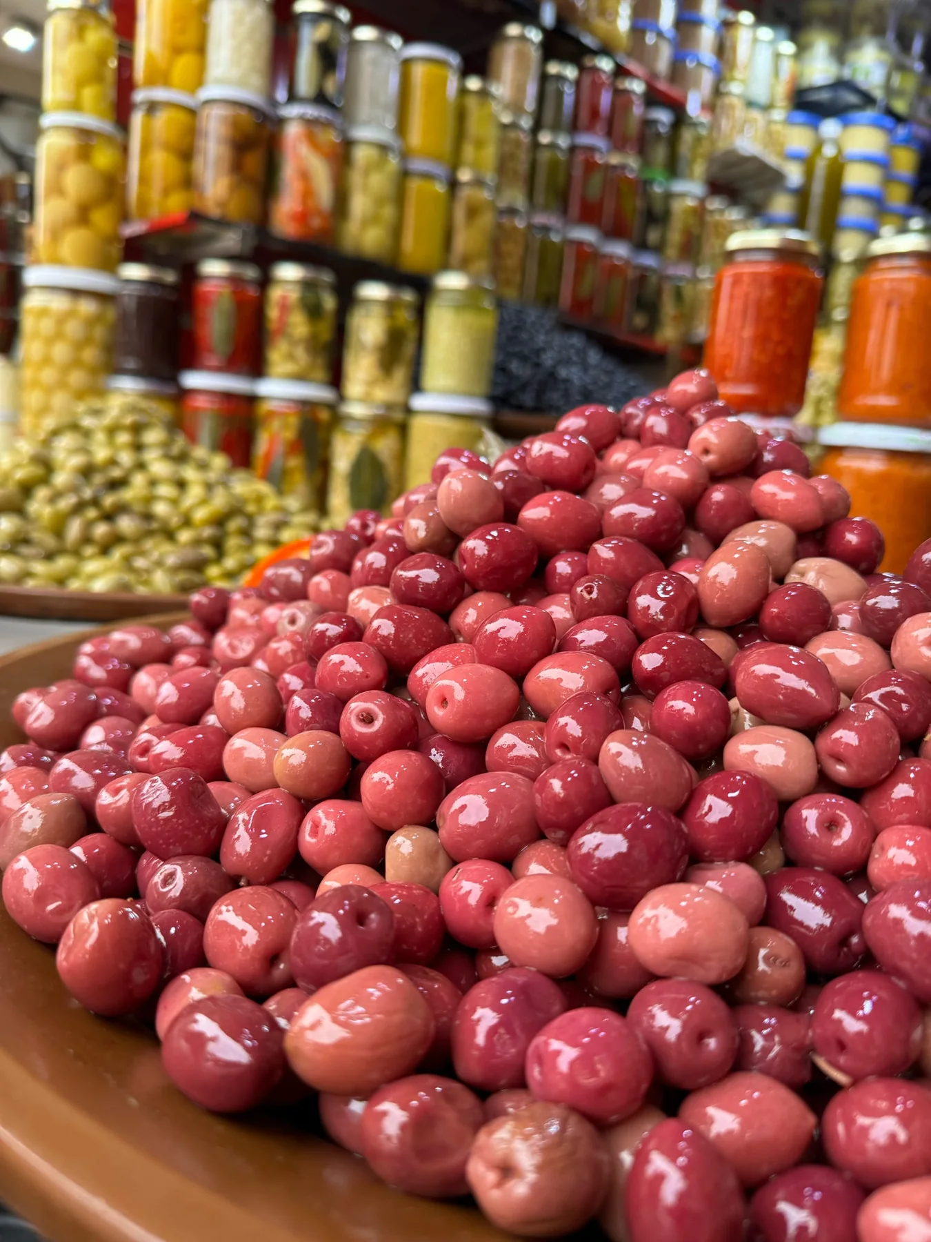 Olives and jars of preserved goods at a Marrakech market stall